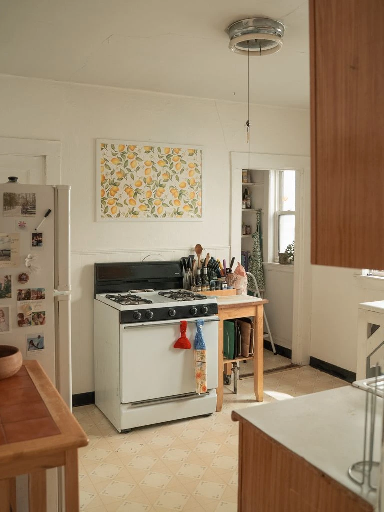 A cooling rack of cinnamon rolls on parchment in a home kitchen